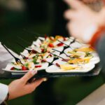 Elegant catering presentation with gourmet appetizers on a tray at a social event.